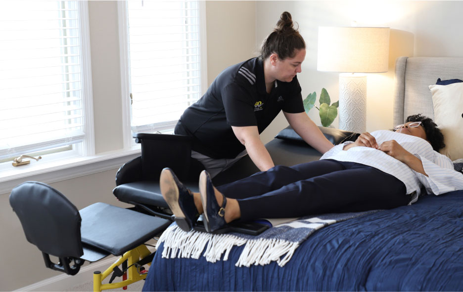 Healthcare Worker Assisting a Woman Move From The Traversa Wheelchair to Her Bed