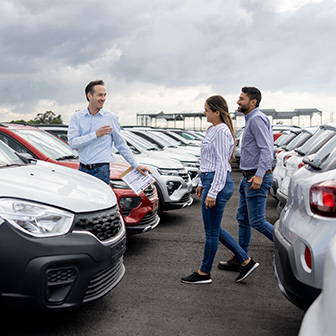 Salesman walking with customers to view vans on the lot