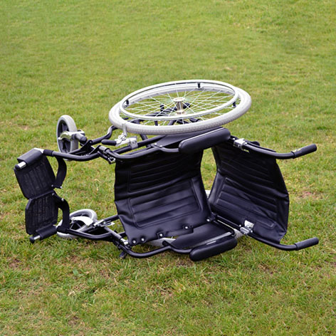 An empty wheelchair tipped over on its side, symbolizing the risk of falls for wheelchair users.