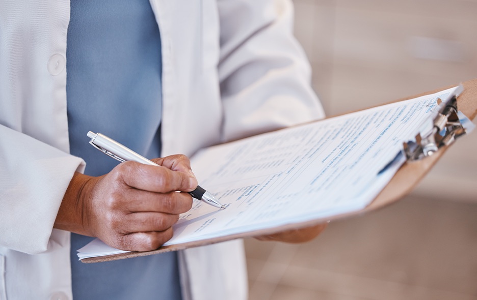Close up of a doctor holding a clipboard and taking notes
