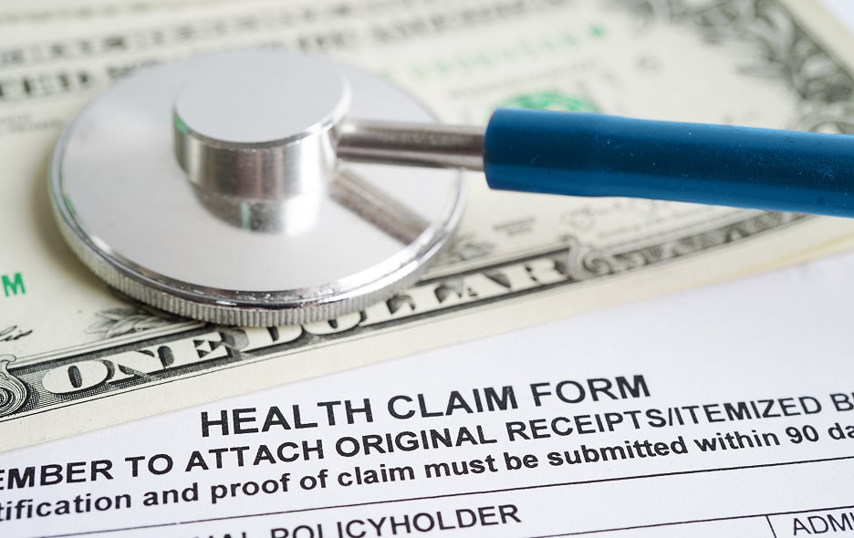 A stethoscope rests on insurance claim paperwork.