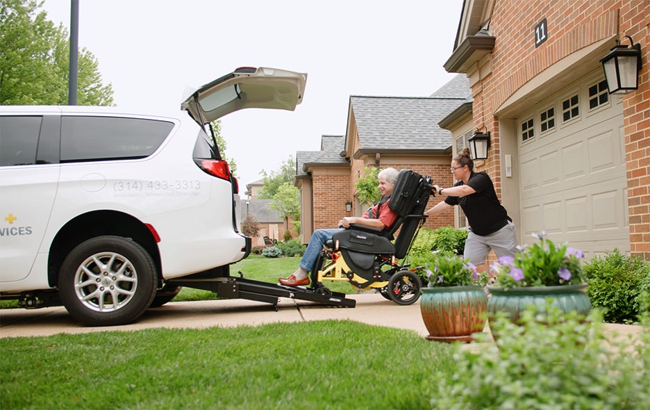 NEMT Operator pushing a passenger in the Traversa Transport Wheelchair up a ramp into a vehicle
